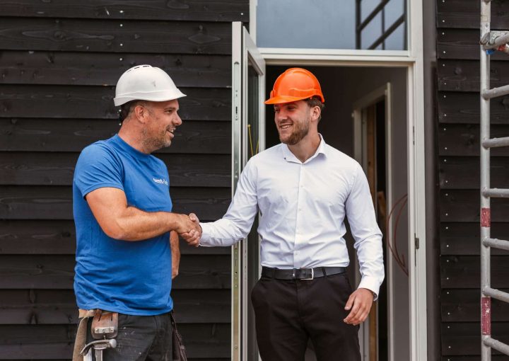 Medewerkers van demt-flex die elkaar een hand geven op de bouwplaats - valkuilen uitzendkracht inhuren
